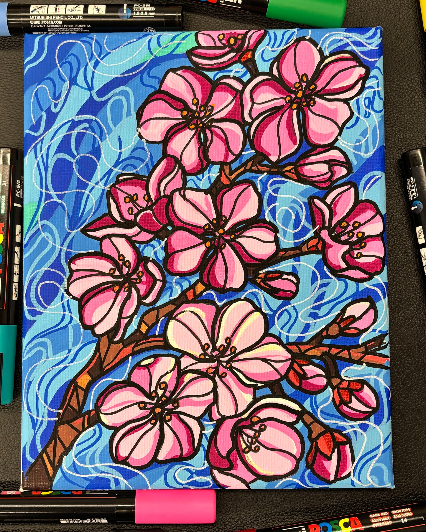 Bright pink painting of cherry blossoms on flowing blue background